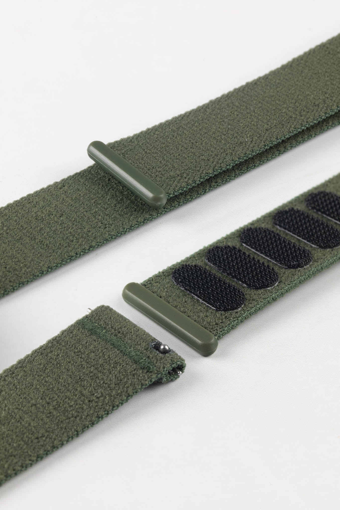 Detail of the quick-release pins and robust hook-and-loop closure of the HIRSCH Vocem Green watch strap.