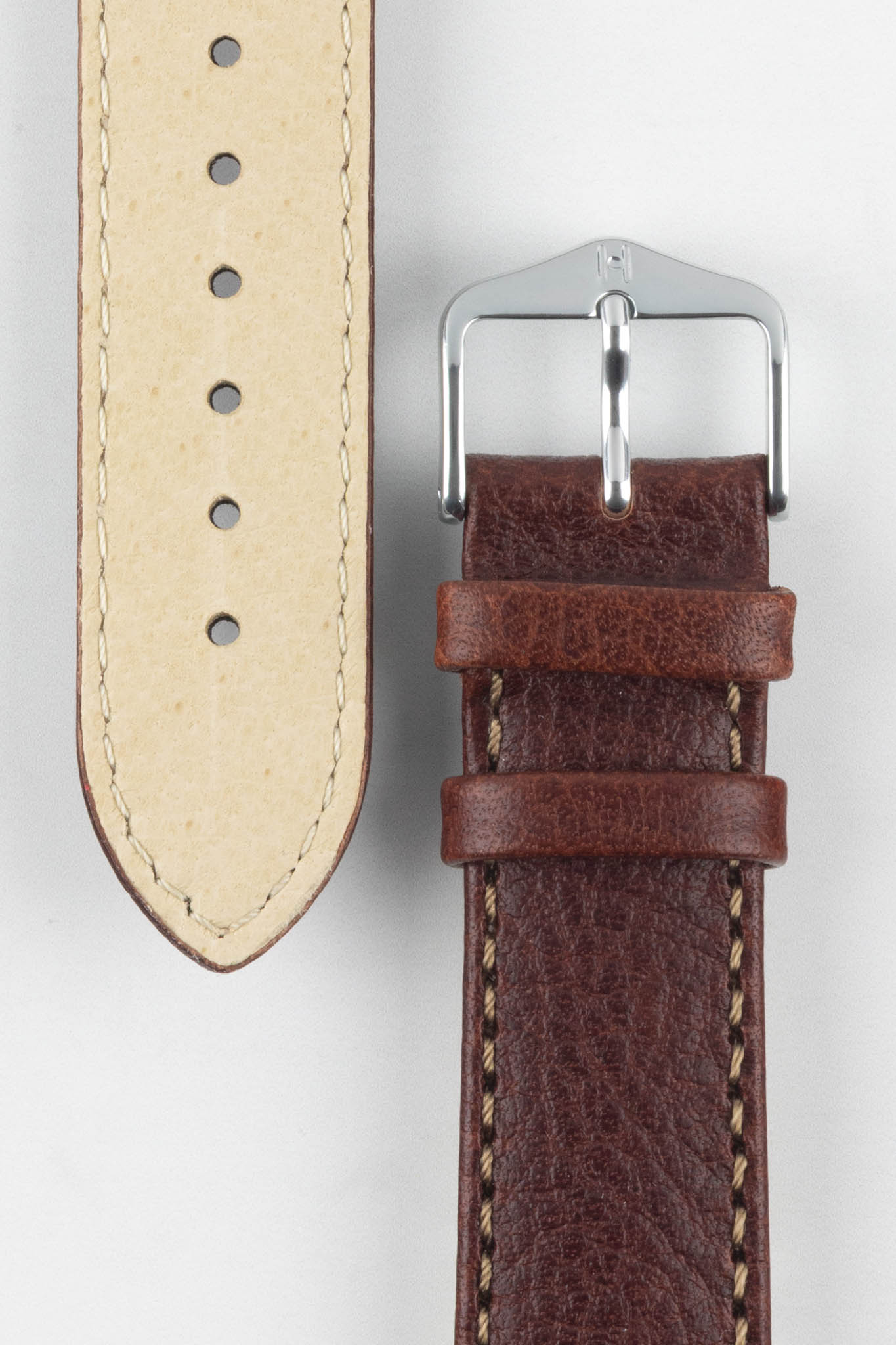Close-up of HIRSCH Forest brown watch strap showing grain texture, tan lining, and classic polished silver buckle for watches.