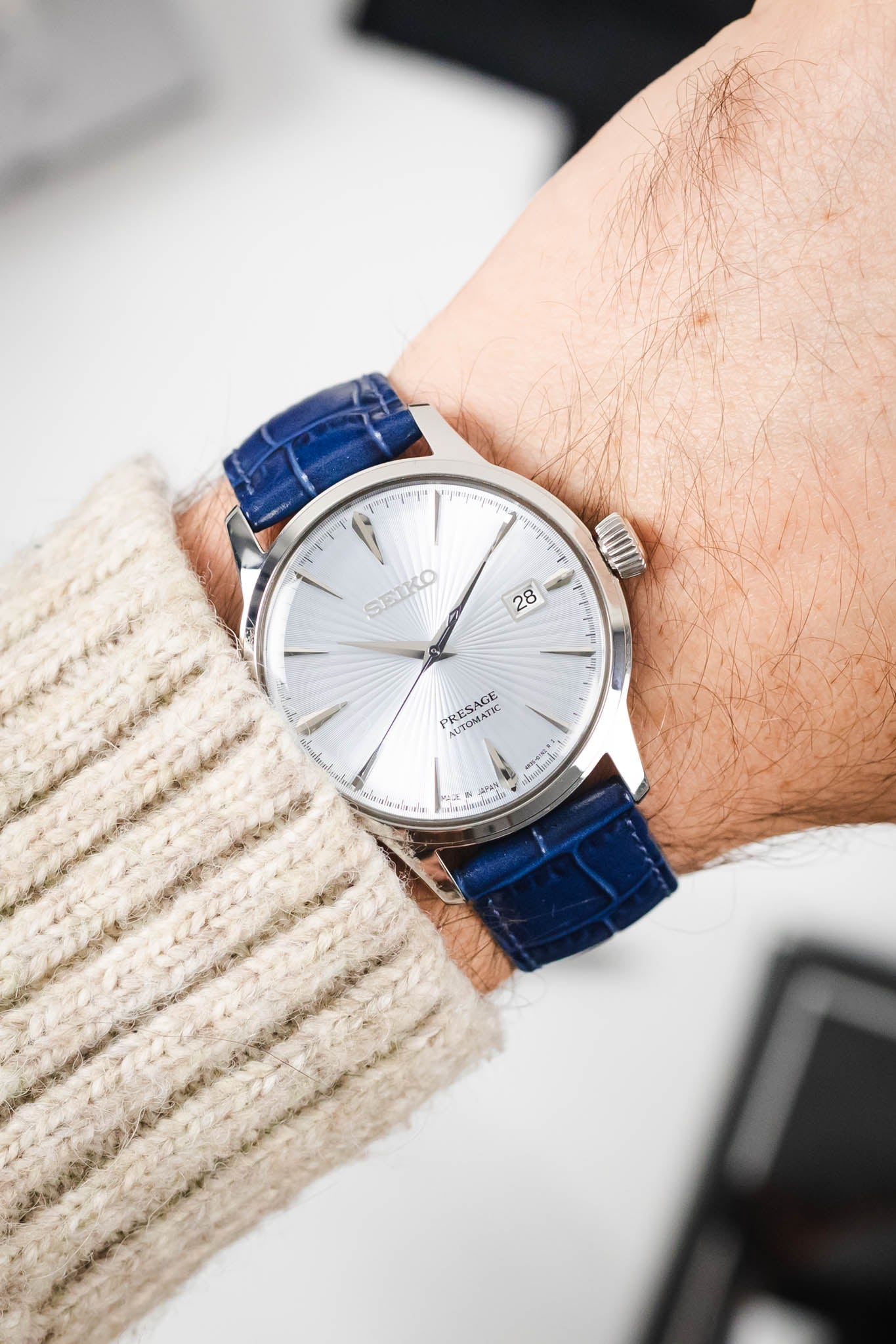 Seiko Presage automatic dress watch with a silver dial on a vibrant blue Louisianalook strap, worn on wrist.