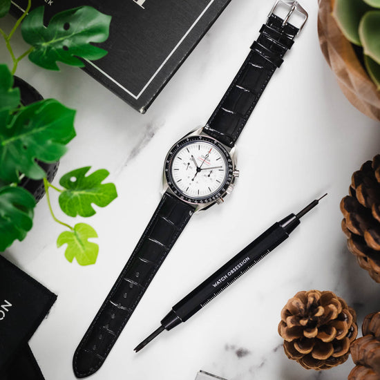 Flat lay of a Seiko Presage watch on a black Louisianalook strap, displayed with a spring bar tool and sunglasses.