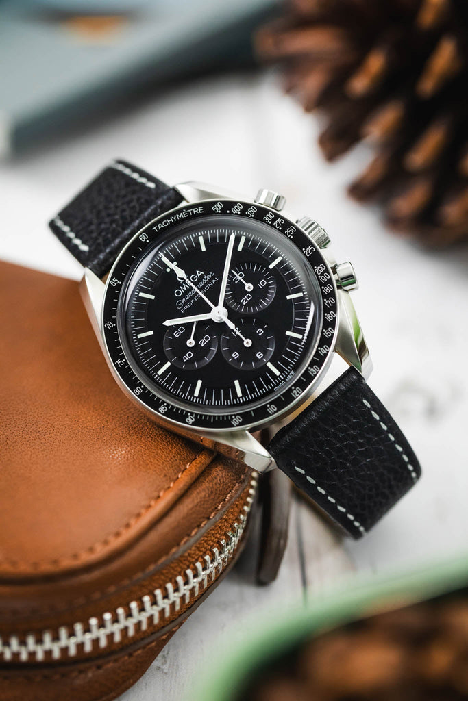 Omega Speedmaster Monnwatch black dial fitted with Hirsch Bologna black leaning on brown leather case