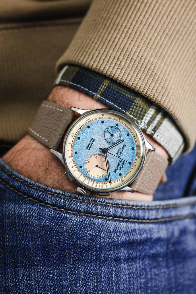 Hirsch Bologna leather watch strap in taupe fitted to Studio Underd0g blue desert sky Time piece worn on wrist with hand in pocket of denim trousers