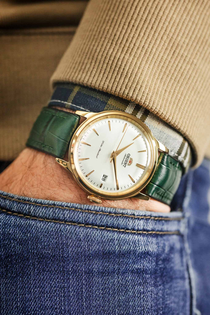 Orient Mens Classic Bambino V2 Watch FAC00003W0 fitted with Hirsch Paul watch strap in Green on wrist with hand in pocket of denim trousers
